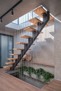 Modern interior staircase with metal balustrade and wooden treads and risers.