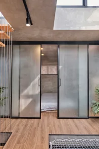 Modern minimalist bedroom featuring frosted glass walls and polished concrete ceiling and floor.