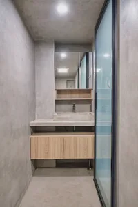 Modern bathroom with minimalist design, featuring a concrete countertop and sink.