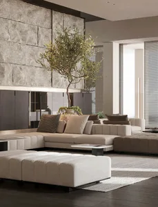Modern minimalist living room featuring a long ottoman upholstered in fabric, with a stone wall and a potted plant.