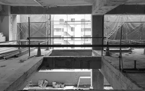 An interior view of a construction site showing concrete beams and scaffolding.