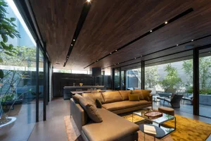 Industrial-style living room with wooden walls, leather couches, and a modern design.