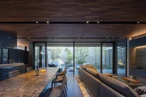 Contemporary residential interior with modern industrial design elements, featuring wood-paneled ceiling and metal accents.