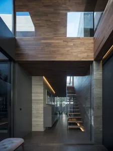 A modern, minimalist staircase with wooden flooring and a contemporary design, featuring a sleek and clean aesthetic.