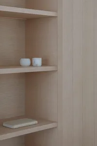 Modern minimalist shelving unit constructed from natural wood, featuring open shelves.