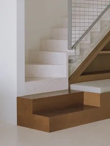Modern concrete staircase with wooden steps and metal railings.