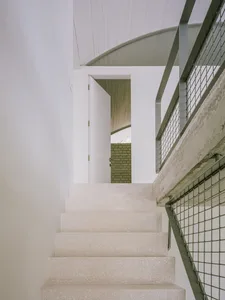 A modern staircase with concrete steps and a metal railing.