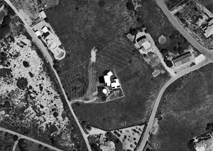 Aerial view of a private residence with a contoured landscape design on a flat surface
