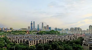 現代都市景觀，混凝土與玻璃建築聳立於多雲天空下。