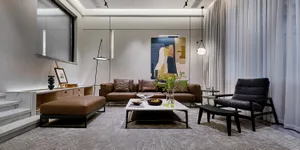 Modern living room with a leather sofa, marble coffee table, and glass pendant lights.