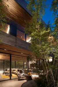 A modern living space featuring a wooden exterior with large windows and a cozy indoor-outdoor area.