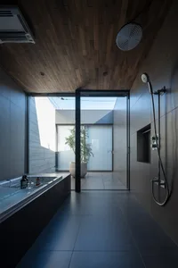 Modern minimalist bathroom featuring glass walls and a large bathtub.