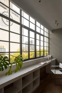 A modern office space featuring a large glass window with a cityscape view.
