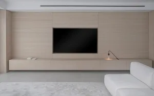 Modern living room featuring a floating wood entertainment unit with a flat-screen TV and minimalistic decor.