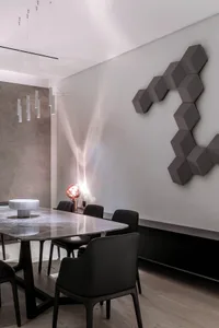Modern dining room with a marble table and black chairs.