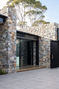 Modern house entry with stone wall and concrete flooring