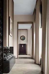 Modern hallway with a wooden floor, warm-toned walls, and fabric curtains.