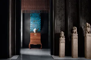 A modern interior design display featuring a wooden pedestal with a white vase, blue wall tiles, and lion statues.