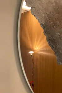 A metal reflector lighting fixture emitting a warm glow in a modern interior design setting.