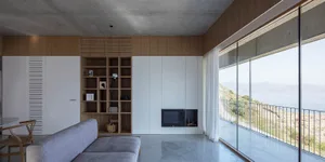 Modern living room with concrete floor and view of mountains.