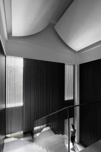 A minimalist staircase with glass railings and a geometric design.