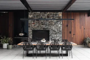 Modern dining room with stone fireplace and wood paneling