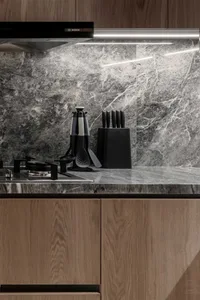 A modern kitchen featuring marble countertops and wooden cabinets.