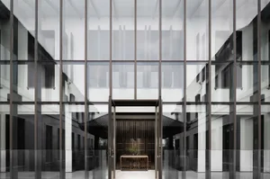 Modern, glass-enclosed lobby with lighting.