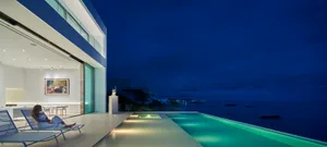 Modern residential exterior featuring glass elements at dusk.