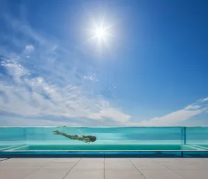 A modern swimming pool with a glass edge and clear blue water.