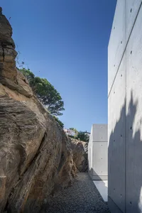 Modern architectural exterior featuring concrete and a roadside path.