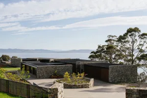 Modern residential home featuring stone, concrete, metal roofing and a planter
