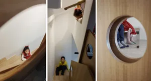 A playful children's playroom featuring a hidden wooden staircase with a peek-through window.