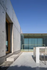 Modern outdoor deck featuring concrete and large glass panels