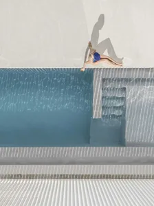 A minimalist swimming pool set against a white background, with a person diving into the pool.