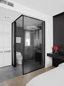 Modern minimalist bathroom suite featuring black glass shower enclosure, marble accents, and concrete floor.