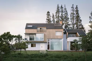 A modern residential home with a dock and pool, featuring wooden exterior, glass windows, and concrete patio.