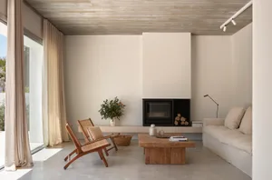 A minimalist living room with concrete, wood, and leather furniture and decor.