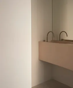 Modern bathroom with minimalist design, featuring a concrete sink and faucet.