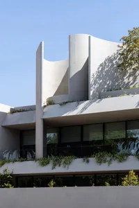 A modern building with curved concrete walls and large windows.