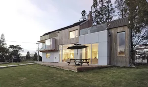 Modern house with a wooden exterior and large windows.