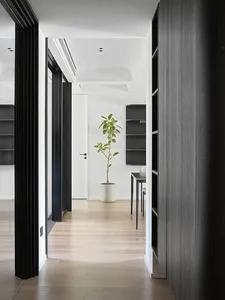 A minimalist interior with wooden flooring and furniture.