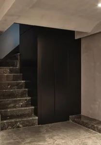 Modern staircase with marble steps and black cabinets