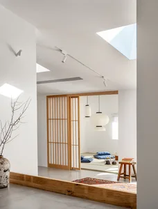A minimalist living room with wooden elements, including a wooden floor, wooden furniture, and a wooden screen.