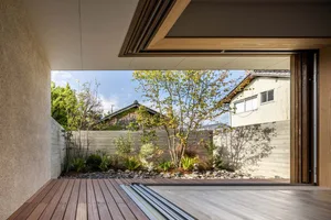 A minimalist residential exterior featuring wood, stone, and metal materials.