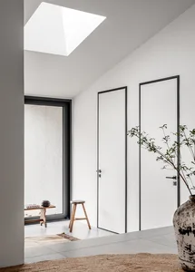 A minimalist white interior with concrete walls and a skylight