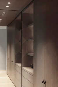 Modern wardrobe with wooden cabinets and built-in shelves.