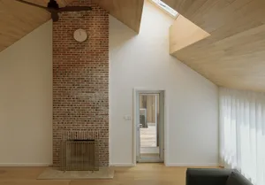 Modern living room featuring brick and wooden walls, glass door, and a cozy fireplace.