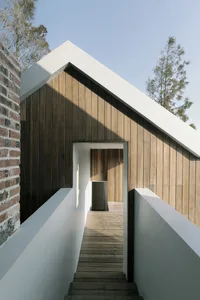 A wooden house exterior photographed outdoors with a clear blue sky.