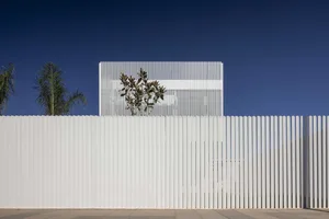 Modern building exterior with metal slats and white walls.